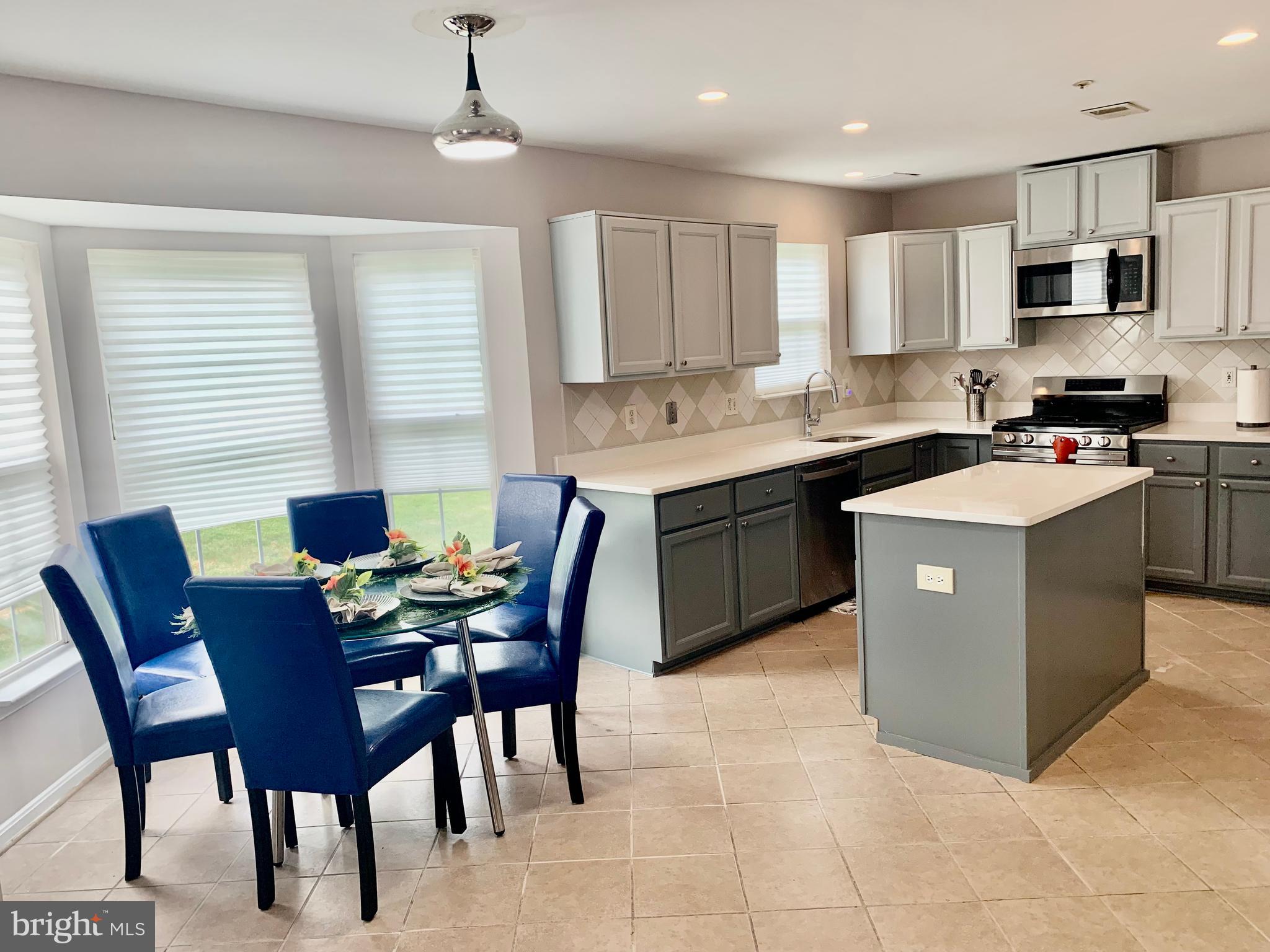 2104 Sayan Court Temple Hills, MD 20748 - Photo 14 of 28 a kitchen that has a table in it and stainless steel appliances