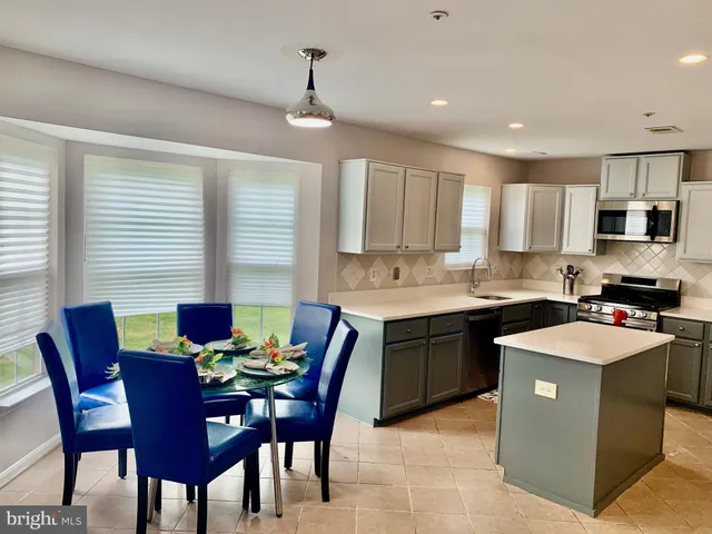 a kitchen with a dining table chairs and white cabinets
