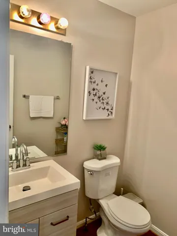 a bathroom with a sink mirror vanity and toilet