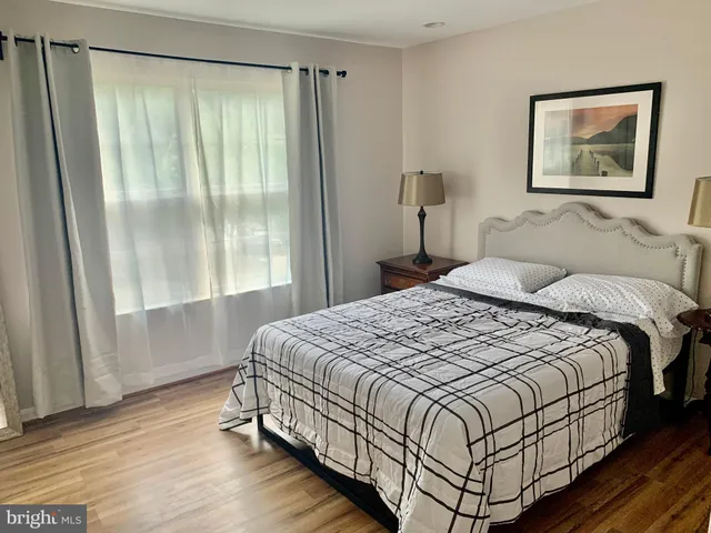 a bedroom with a bed and a large window