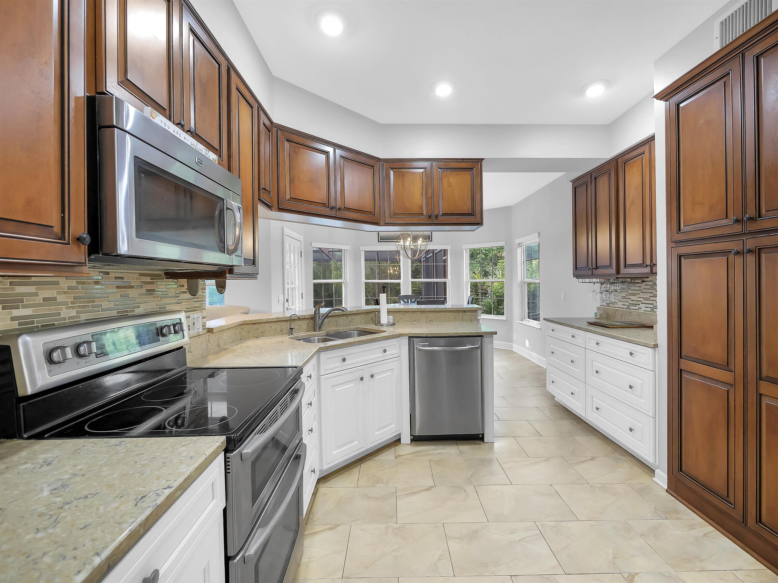 306 Marsh Point Circle St. Augustine, FL 32080 - Photo 3 of 54 a kitchen with granite countertop a stove top oven sink and cabinets