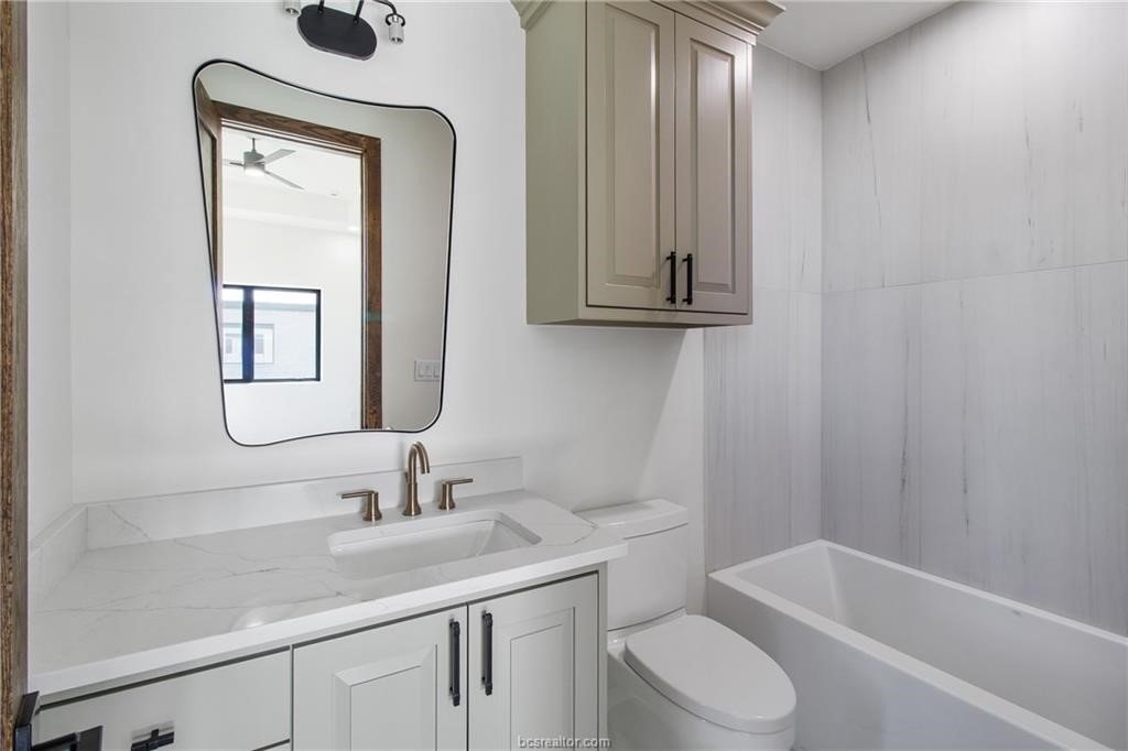 4558 Hicks Lane Bryan, TX 77845 - Photo 25 of 48 a bathroom with a toilet a sink and mirror