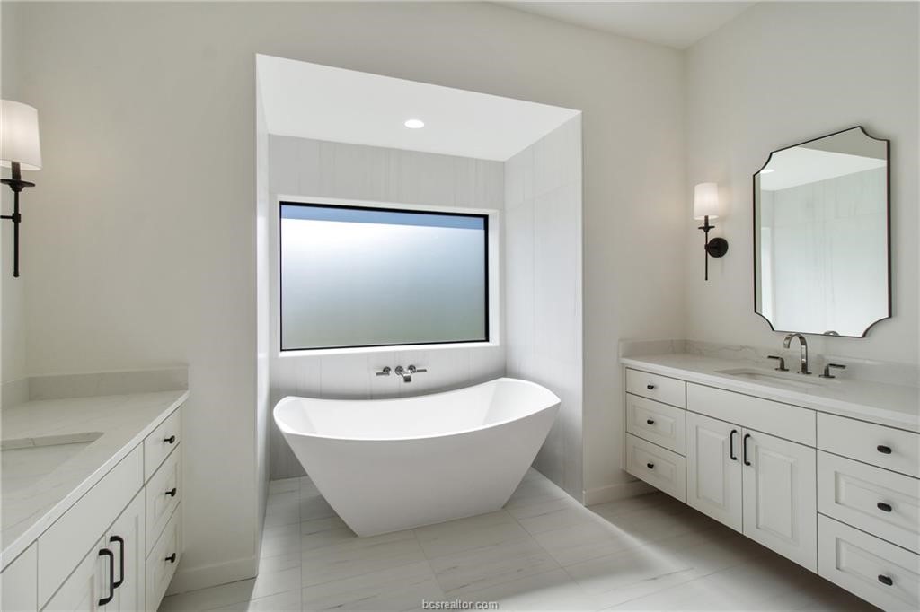 4558 Hicks Lane Bryan, TX 77845 - Photo 31 of 48 a spacious bathroom with a double vanity sink mirror and bathtub