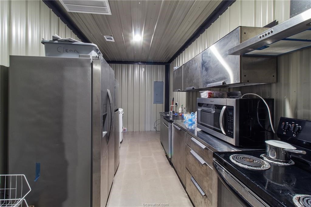 4558 Hicks Lane Bryan, TX 77845 - Photo 42 of 48 a kitchen with stainless steel appliances granite countertop a refrigerator and a stove