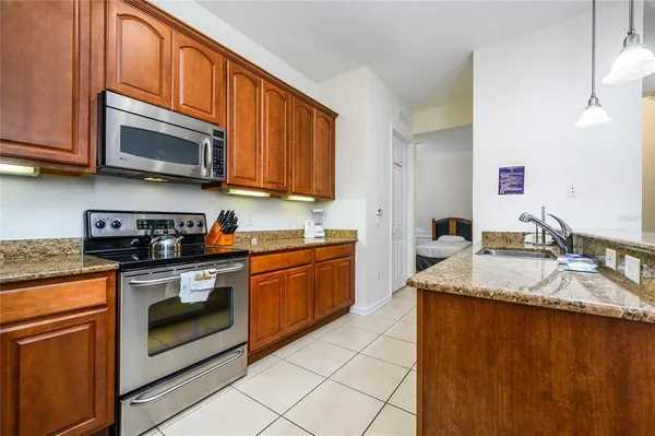 a kitchen with stainless steel appliances granite countertop a sink stove and microwave