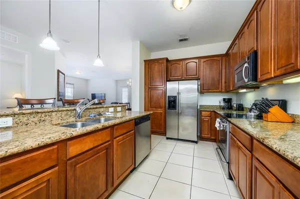a kitchen with stainless steel appliances granite countertop a sink a stove and a refrigerator