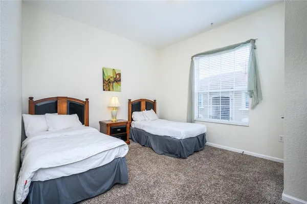 a bedroom with two beds and a window