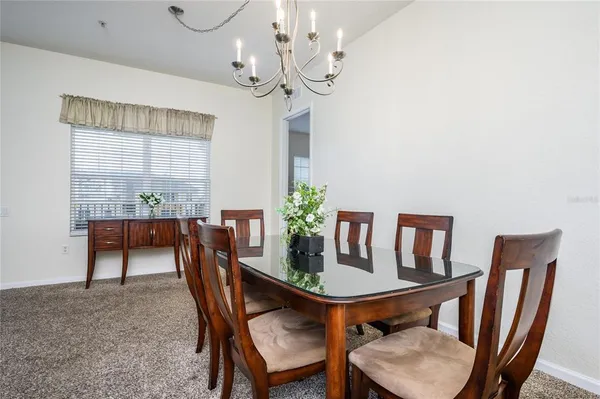 a view of a dining room with furniture and a chandelier