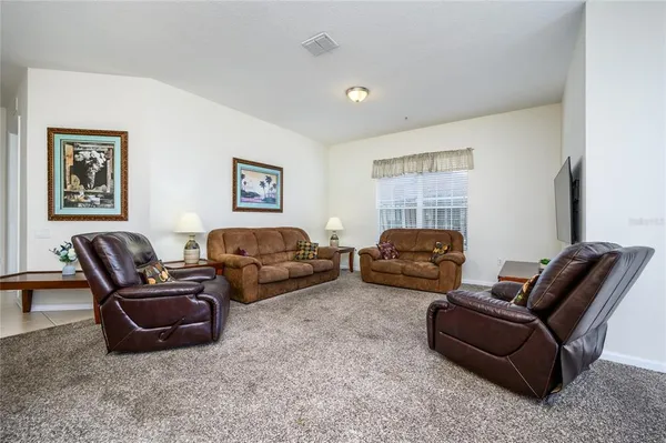 a living room with furniture a couch and two windows