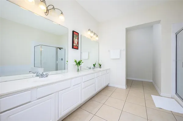 a spacious bathroom with a double vanity sink and a mirror