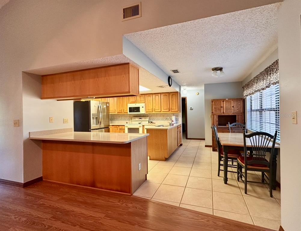 5912 Bailey Road Plant City, FL 33565 - Photo 9 of 30 a kitchen with stainless steel appliances kitchen island granite countertop a stove a sink and a refrigerator
