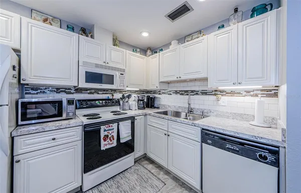 a dining hall with stainless steel appliances granite countertop furniture and a dining table