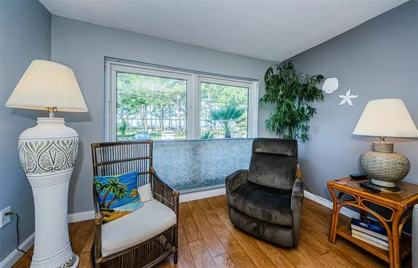 a view of a room with a large window and wooden floor