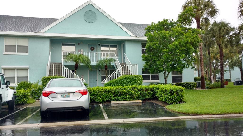 137 Wading Bird Circle, Unit F206 Naples, FL 34110 - Photo 2 of 11 a front view of a house with a yard
