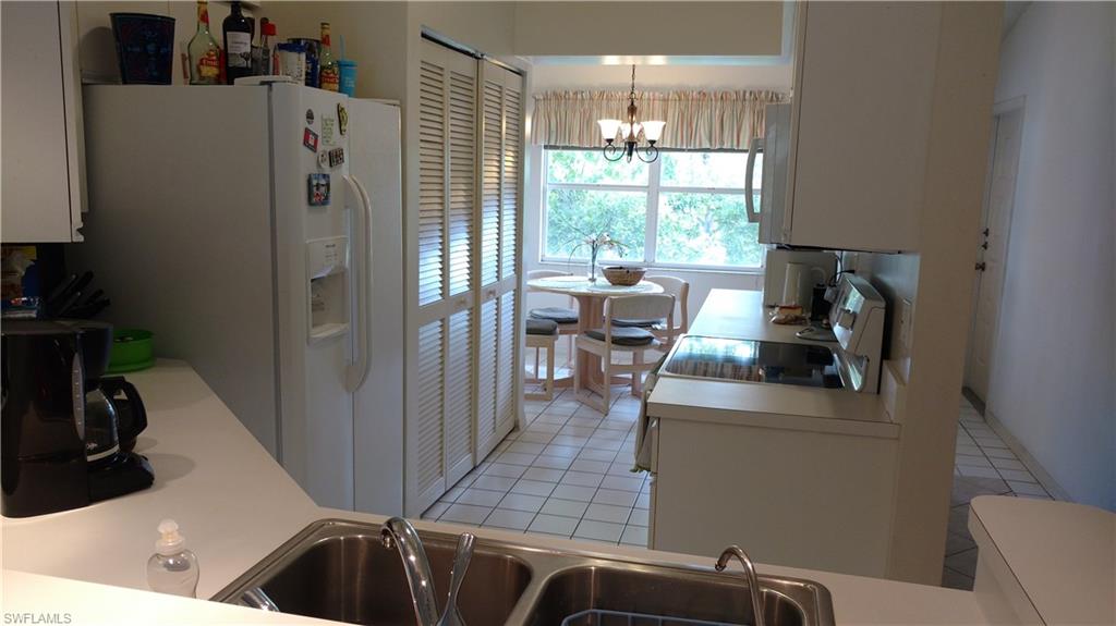 137 Wading Bird Circle, Unit F206 Naples, FL 34110 - Photo 5 of 11 a kitchen with refrigerator and window