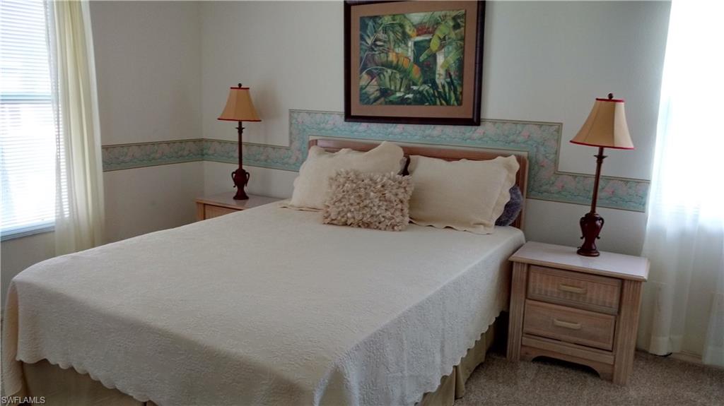 137 Wading Bird Circle, Unit F206 Naples, FL 34110 - Photo 6 of 11 a bedroom with a bed and a painting on the wall
