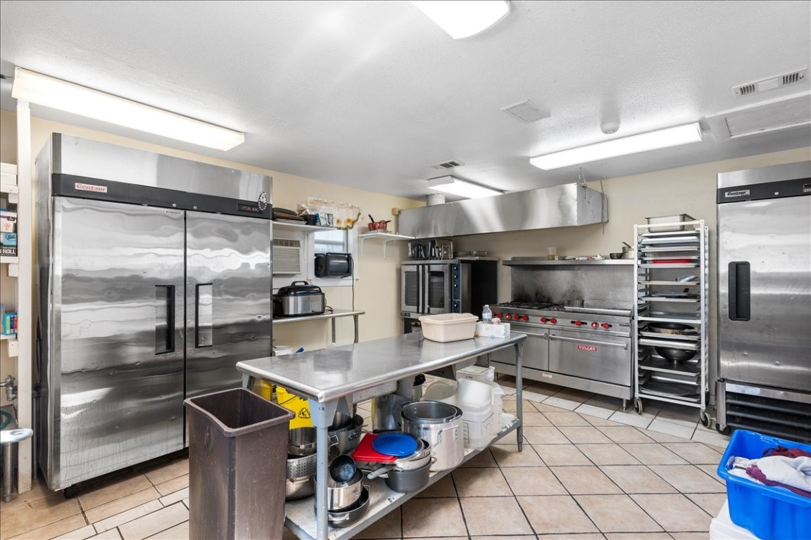 2606 Santa Rosa Street Austin, TX 78702 - Photo 18 of 28 Kitchen with stainless steel counters, light tile patterned floors, and stainless steel refrigerator