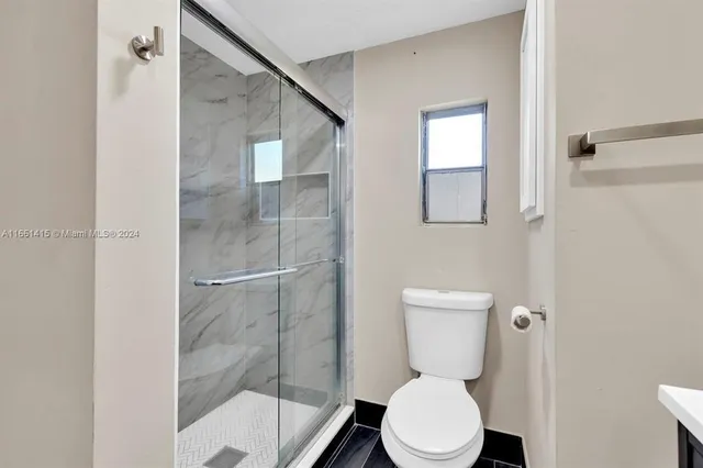 a bathroom with a toilet and a shower
