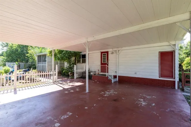 a view of a patio with table and chairs and wooden fence