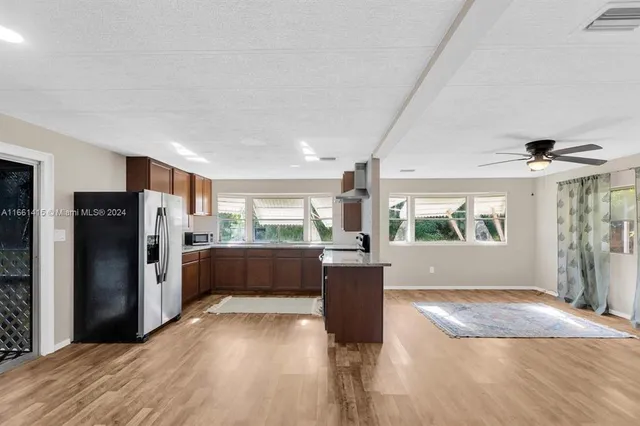 a view of a kitchen with a refrigerator and a stove top oven