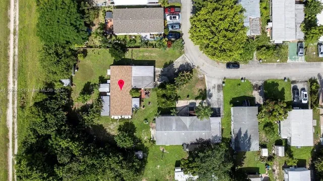 an aerial view of a house with a yard and a large pool