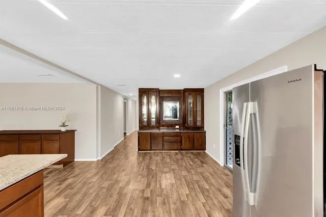 a large kitchen with a refrigerator a stove top oven a sink and dishwasher