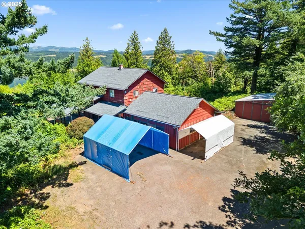 an aerial view of a house with swimming pool and trees