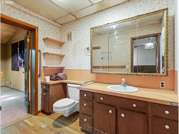 a bathroom with a granite countertop toilet a sink a mirror and a shower
