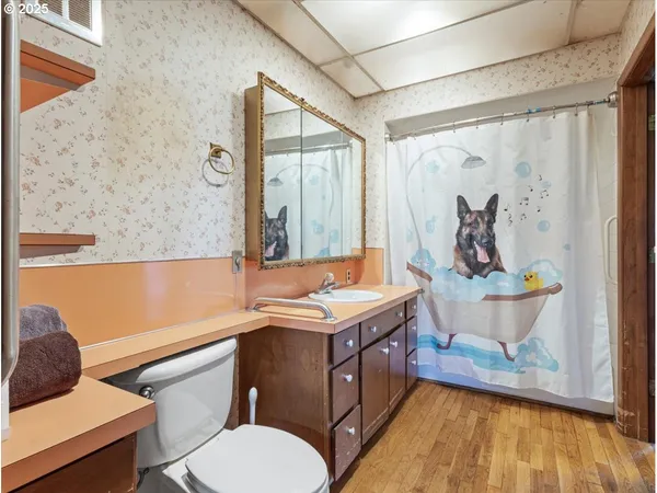 a bathroom with a granite countertop sink a toilet and a shower curtain