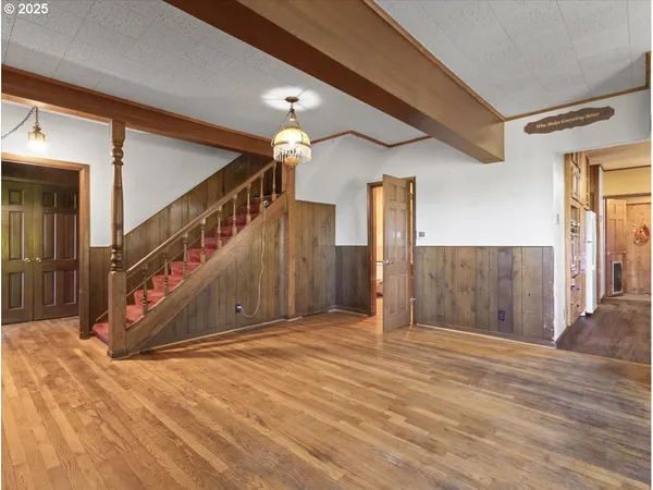 a view of a hallway with wooden floor and staircase