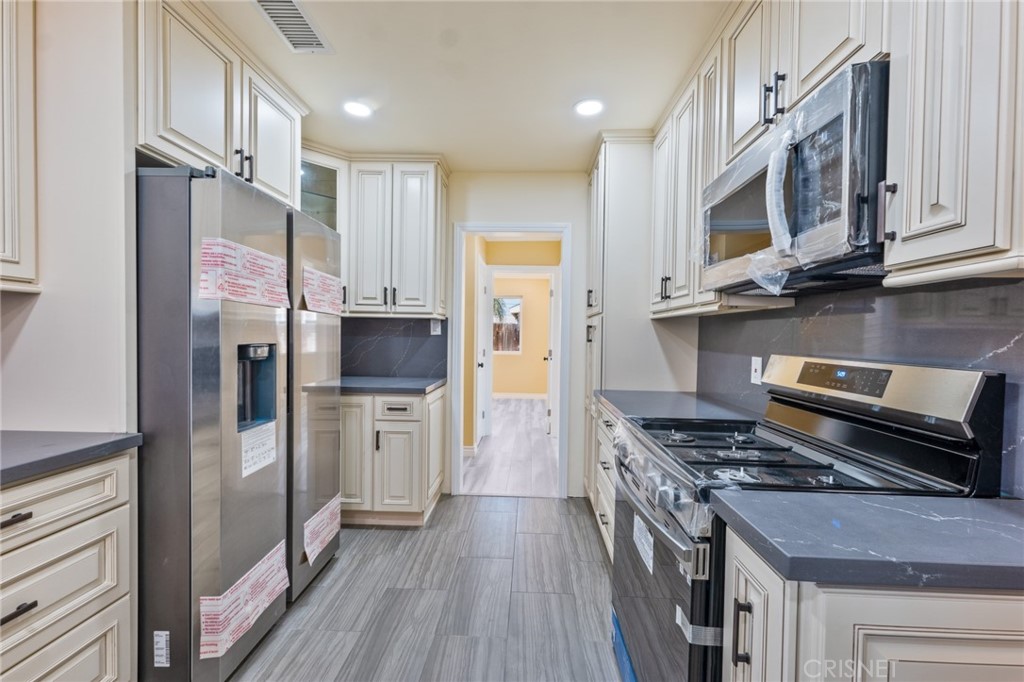 17604 Willard Street Northridge, CA 91325 - Photo 5 of 28 a kitchen with stainless steel appliances a refrigerator a stove top oven and sink