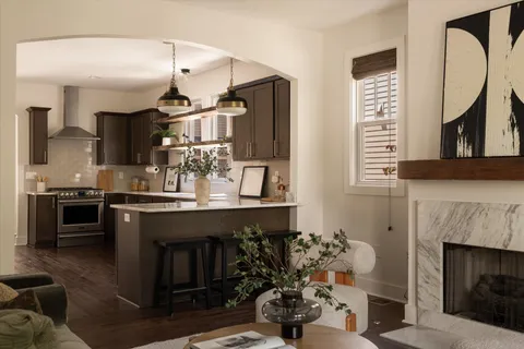 a kitchen with kitchen island granite countertop stainless steel appliances a stove a sink and cabinets