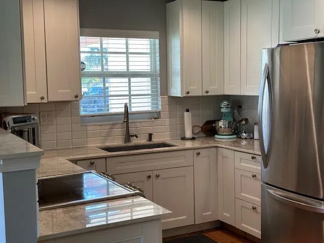 a kitchen with stainless steel appliances a refrigerator sink and cabinets