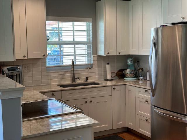 4585 Northwest 3rd Street, Unit D Delray Beach, FL 33445 - Photo 12 of 42 a kitchen with stainless steel appliances a refrigerator sink and cabinets