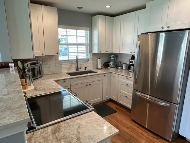 a kitchen with a sink a refrigerator a microwave a sink and cabinets