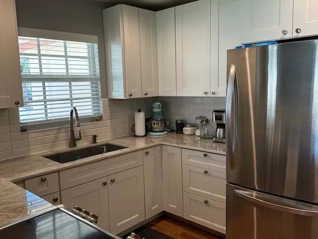 a kitchen with white cabinets and a refrigerator