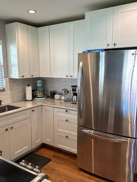 4585 Northwest 3rd Street, Unit D Delray Beach, FL 33445 - Photo 19 of 42 a kitchen with stainless steel appliances granite countertop a refrigerator sink and white cabinets with wooden floor