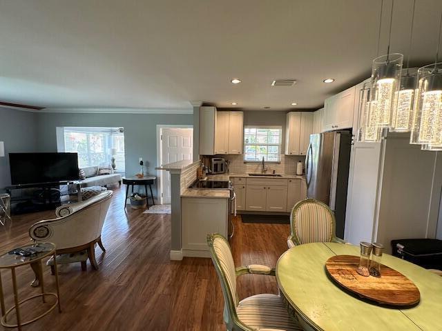 4585 Northwest 3rd Street, Unit D Delray Beach, FL 33445 - Photo 20 of 42 a kitchen with stainless steel appliances kitchen island granite countertop a refrigerator a stove a sink a dining table and chairs with wooden floor