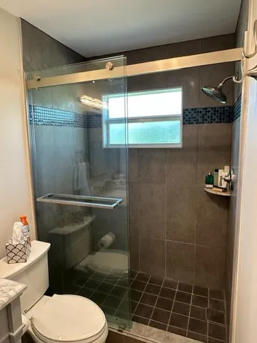 a bathroom with a toilet and a shower