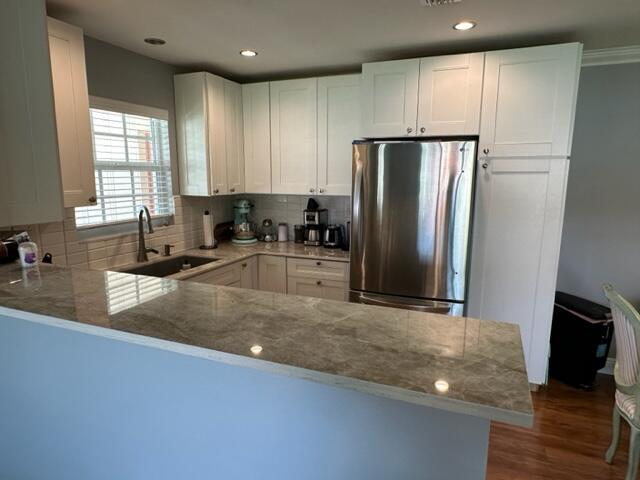 4585 Northwest 3rd Street, Unit D Delray Beach, FL 33445 - Photo 8 of 42 a kitchen with stainless steel appliances granite countertop a refrigerator a stove and a sink with wooden floors