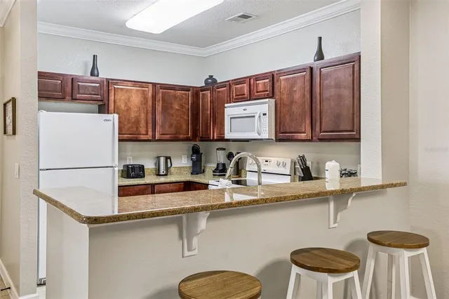 a kitchen with stainless steel appliances granite countertop a refrigerator sink stove and microwave