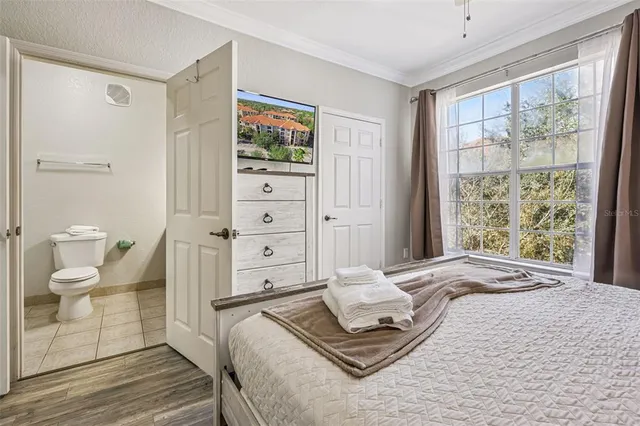 a bedroom with a large bed and a chandelier