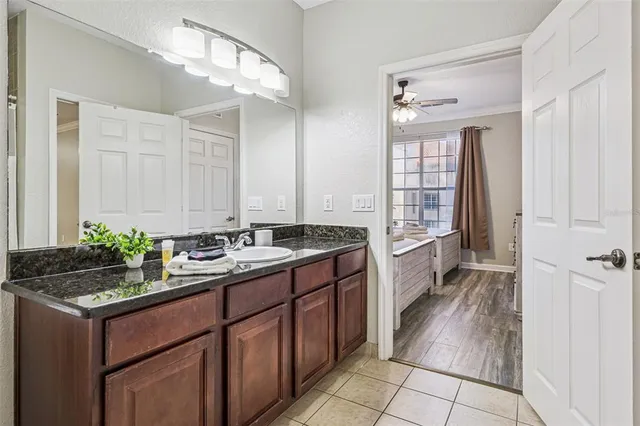 a bathroom with a granite countertop sink a toilet and a mirror