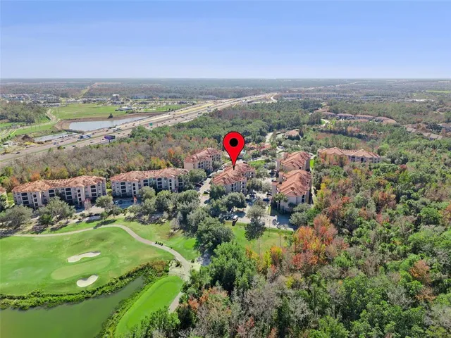 a view of a white house with a swimming pool and lawn chairs