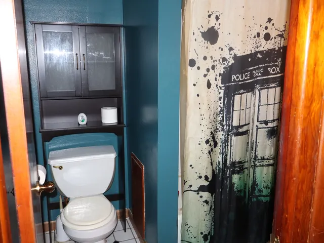 a bathroom with a toilet a sink and glass door