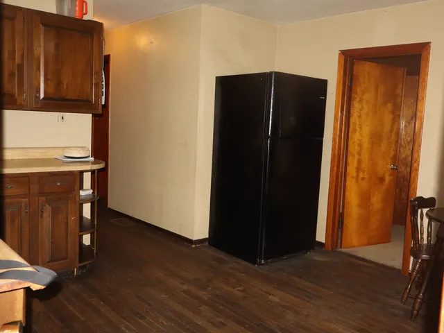 an empty room with wooden floor and a cabinet