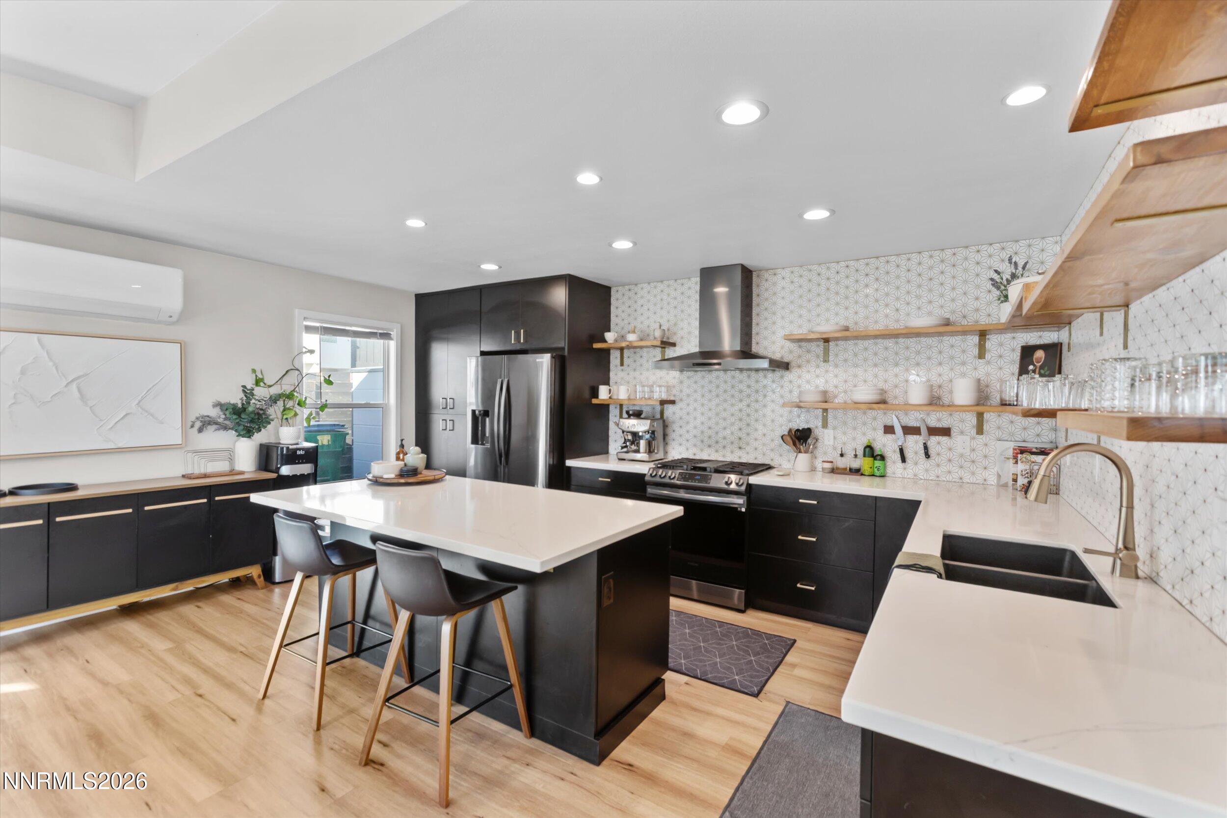 536 Sinclair Street Reno, NV 89501 - Photo 3 of 24 a kitchen with stainless steel appliances granite countertop a sink a stove a refrigerator a kitchen island with chairs and wooden floor