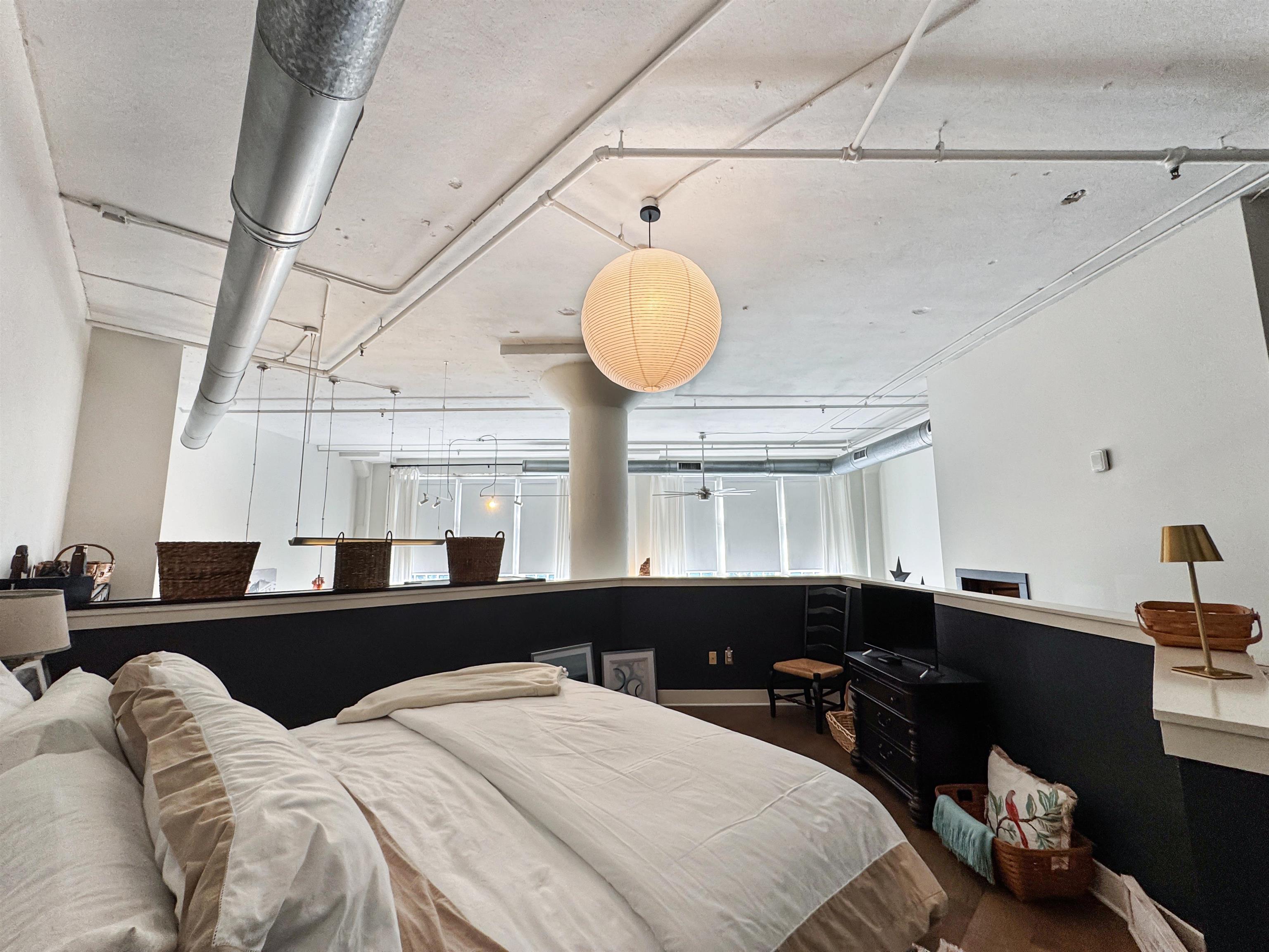 505 Tennessee Street, Unit 213 Memphis, TN 38103 - Photo 19 of 33 a bedroom with a bed and a chandelier