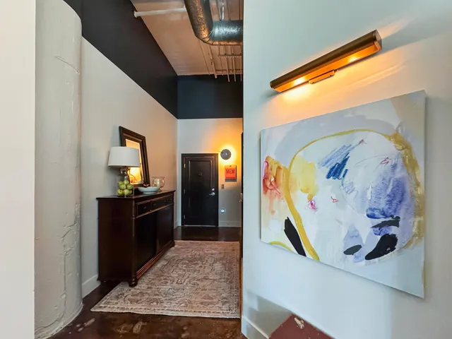 a view of a hallway with wooden floor and furniture
