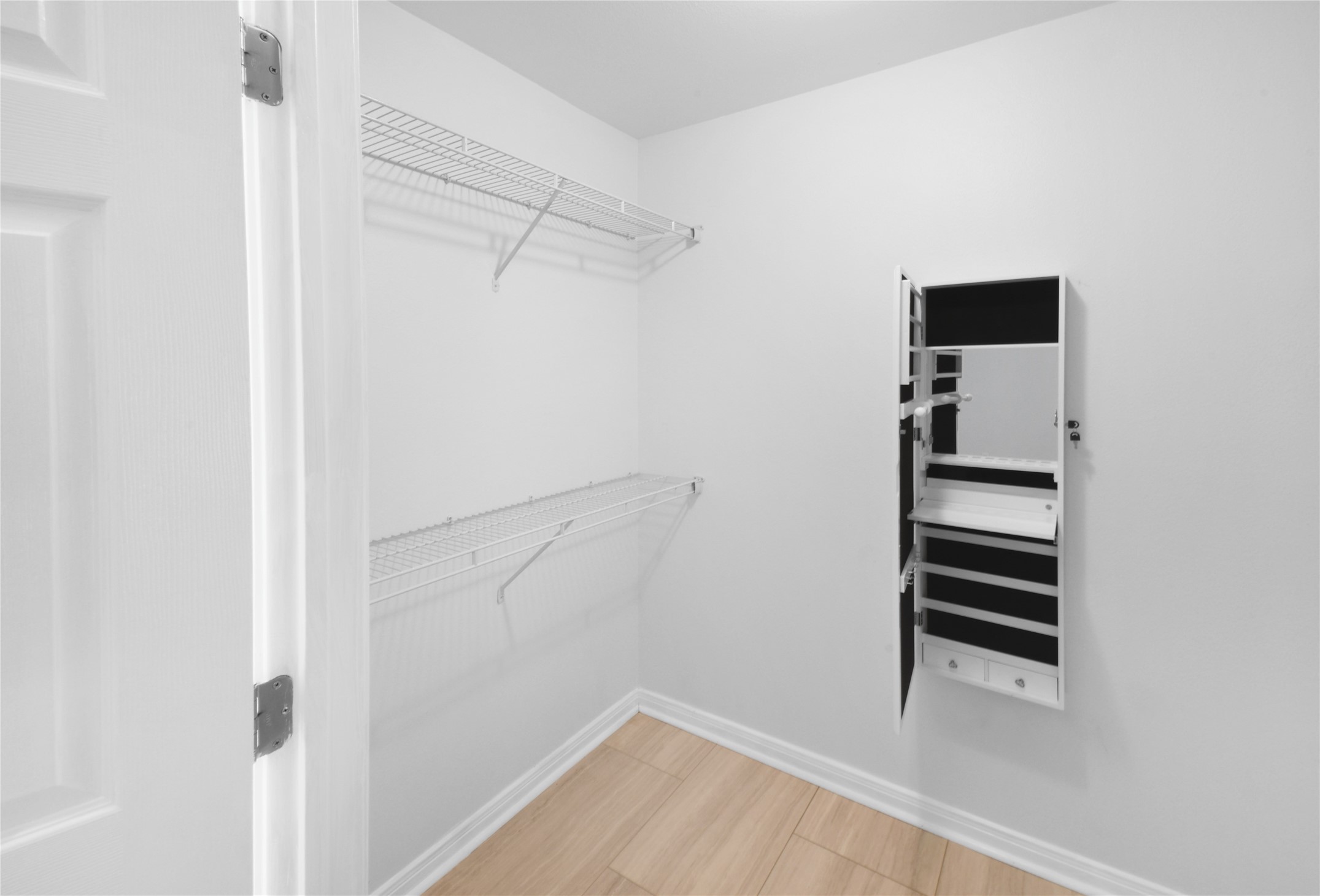 320 10th Street Dickinson, TX 77539 - Photo 19 of 21 Discover your new wardrobe haven in this sleek and organized primary closet, offering ample shelving and a built-in vanity for effortless style and storage.